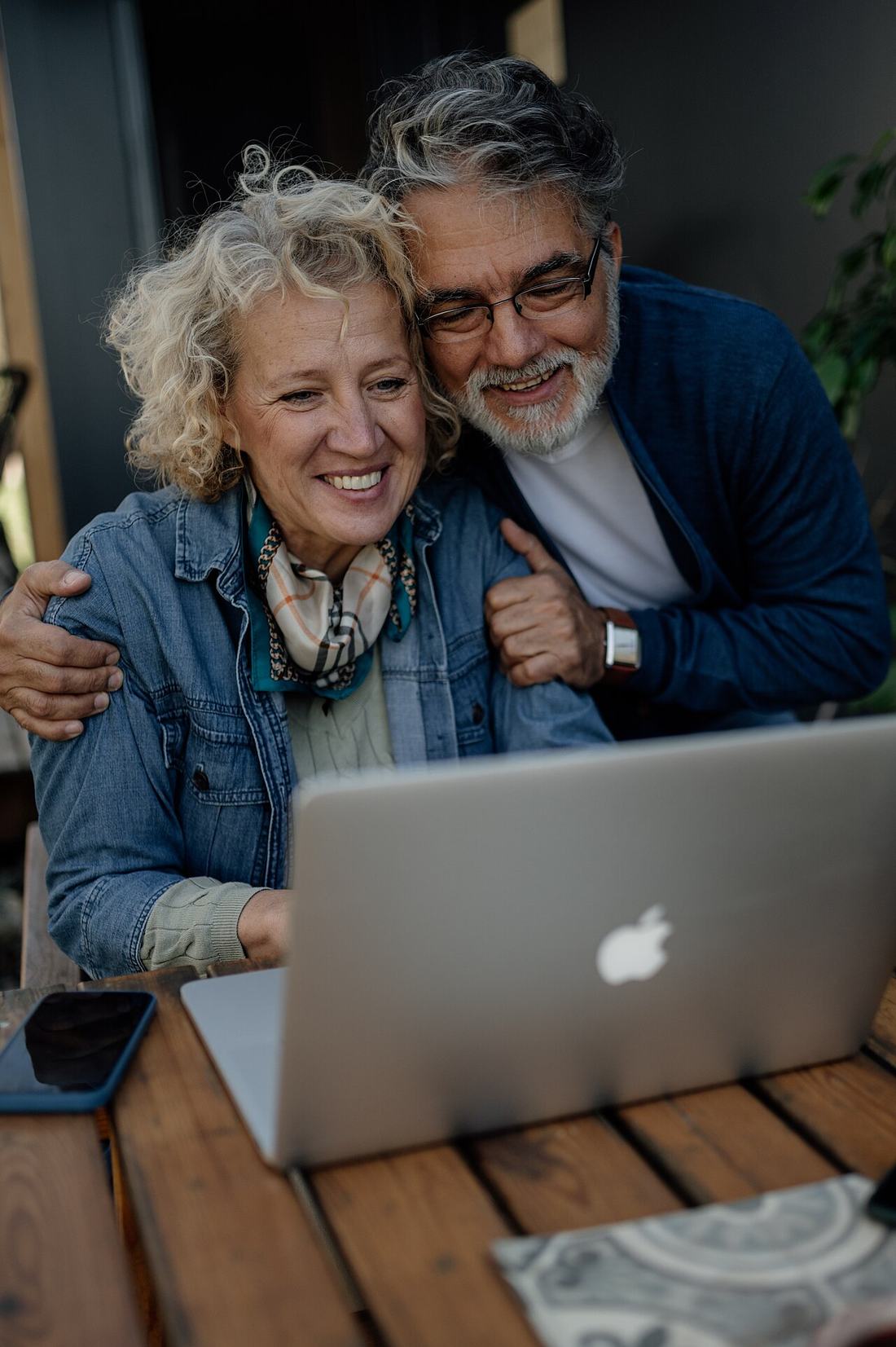 Beautiful senior couple working on laptop in the garden