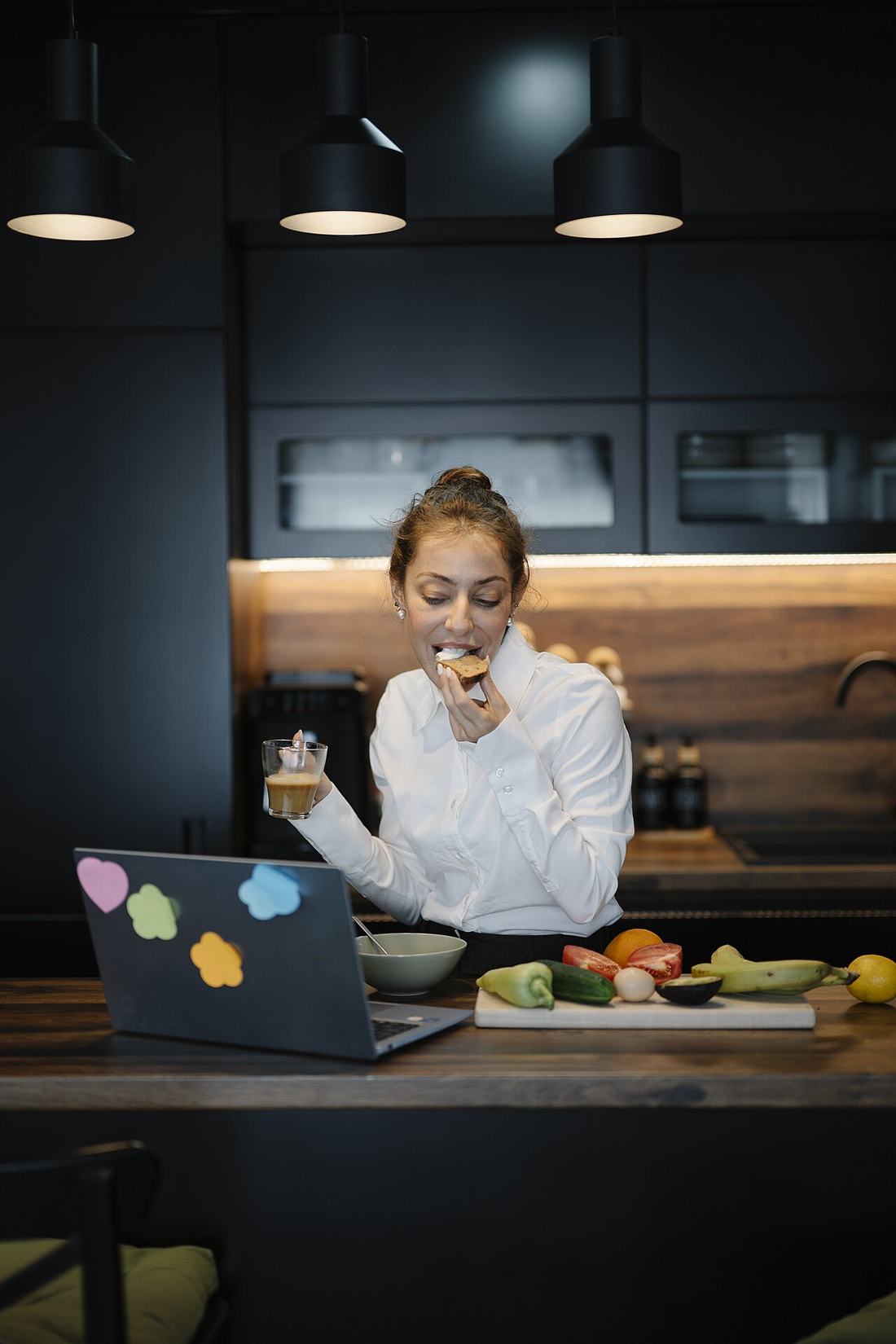 Woman working on a laptop at a kitchen table